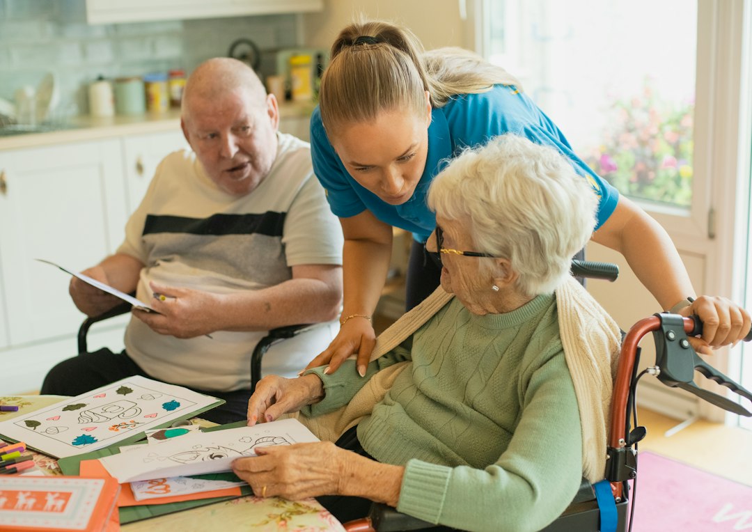 Care worker helping older adults with a creative activity